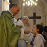 Il Vescovo distribuisce la comunione ai bambini