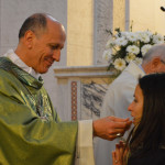 Il Vescovo distribuisce la comunione ai giovani