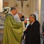 Il Vescovo distribuisce la comunione agli adulti